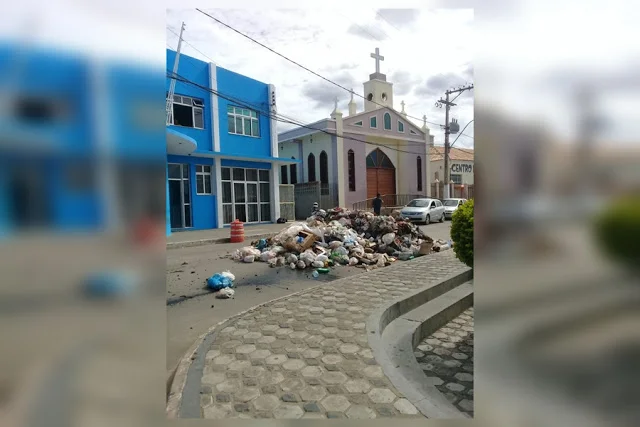 Funcionários descarregam caminhão de lixo em frente a prefeitura em protesto por atraso em salários