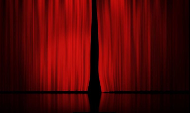 Imagem ilustra a oficina de teatro com a uma cortina vermelha sobre um palco de teatro