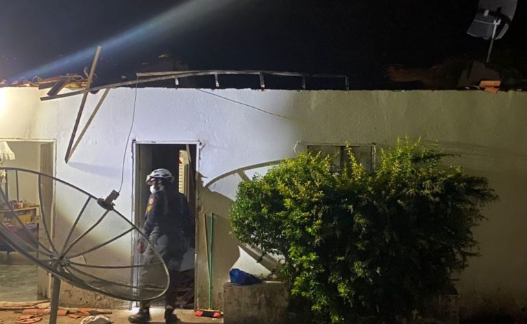 Foto mostra um bombeiro militar em frente a porta da residência cujo telhado desabou