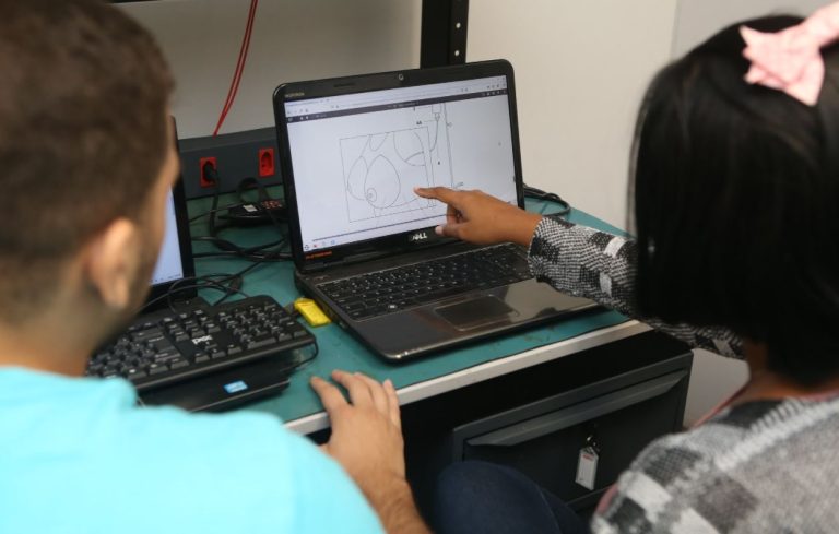Foto mostra duas pessoas em frente a um notebook discutindo algum projeto - Edital do Programa Centelha
