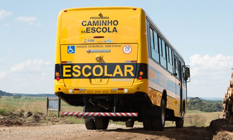 Imagem mostra parte traseira do ônibus escolar ORE 3 em uma estrada vicinal