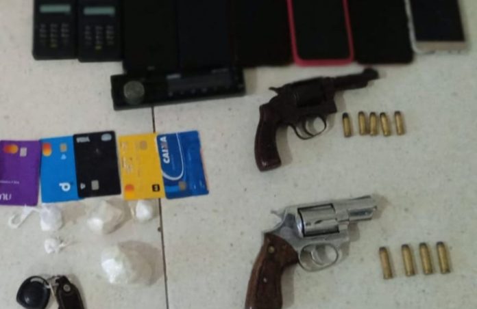Foto mostra armas, munições, cartões, celulares e porções de cocaína apreendidas em Vitória da Conquista