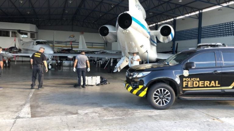 Foto mostras policiais durante diligências no hangar do aeroporpoto