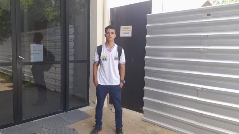 Foto mostra estudante medalha de bronze vestindo o uniforme da rede pública