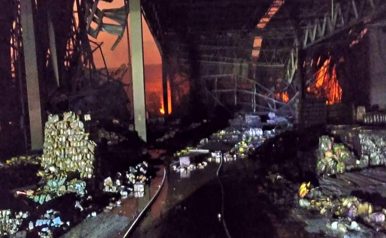 Foto mostra interior do prédio onde ainda há chamas consumindo as mercadorias