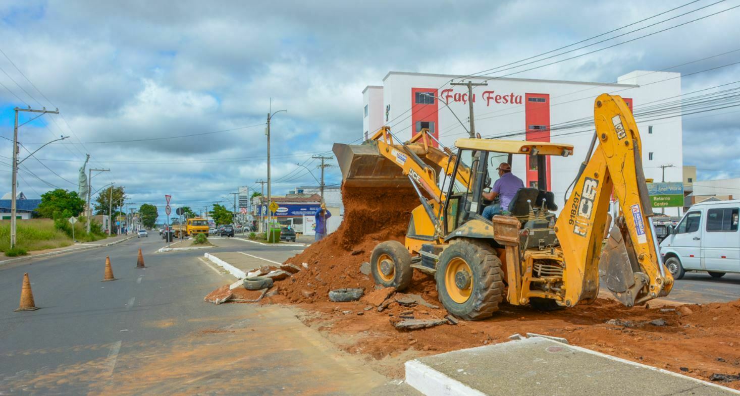 Foto mostra retroescavadeira preparando canteiro da avenida para instalação do semáforo
